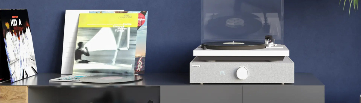 Lifestyle view of a white SpinBase 2 supporting a turntable beside displayed records.