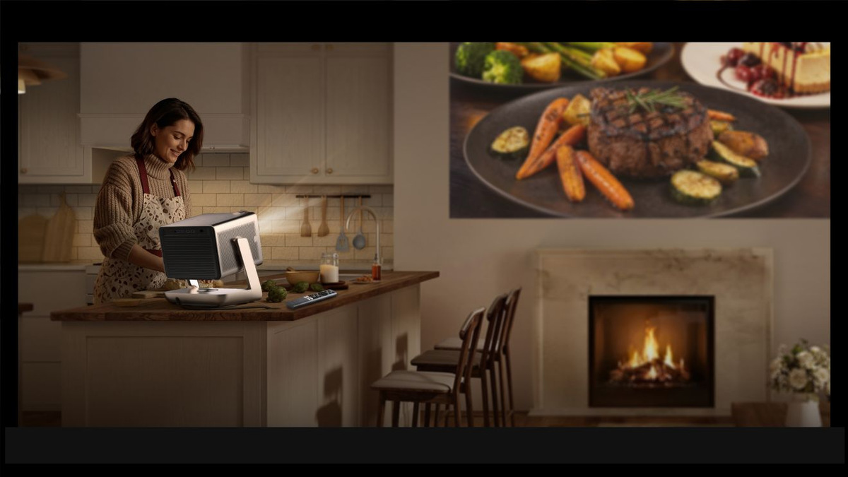 Person preparing food beside a projector while a meal is projected on the kitchen wall.