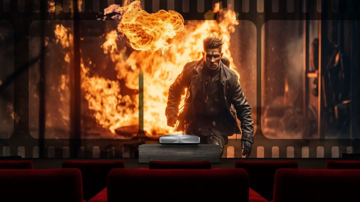 Hisense PX4 Pro projecting an action scene with a man walking in front of flames, viewed over cinema seats.